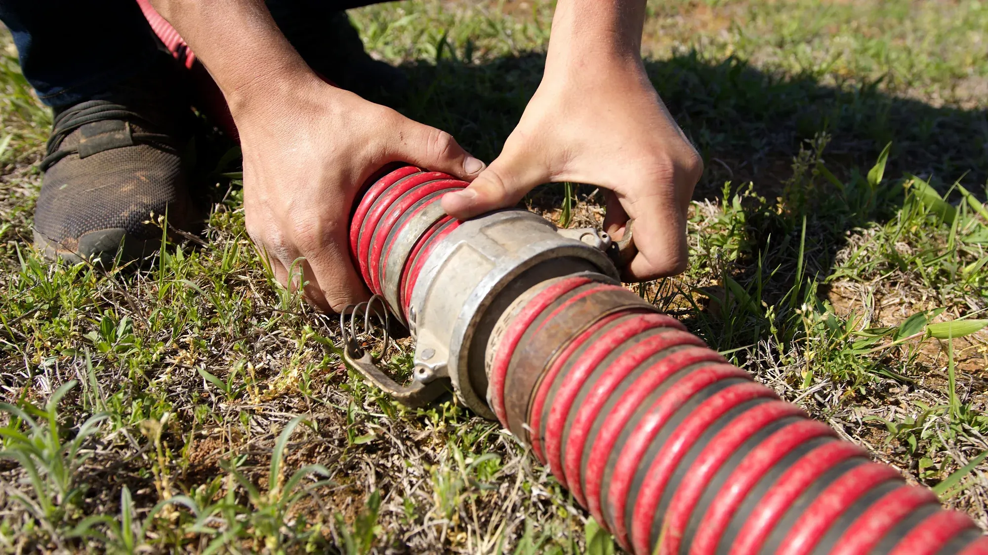 K&M technician connecting a pump hose at a residential septic tank